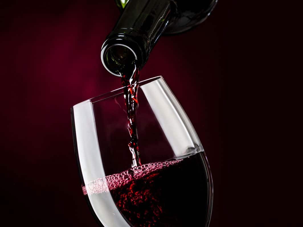 Ein Glas wird mit Rotwein gefüllt